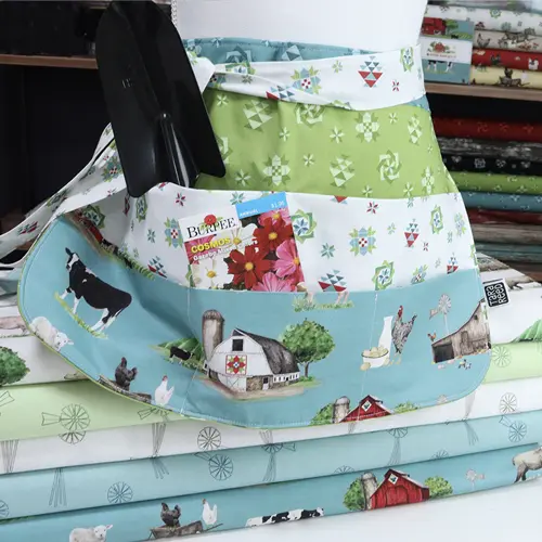 DIY garden apron on a pile of Spring Barn Quilts fabric bolts