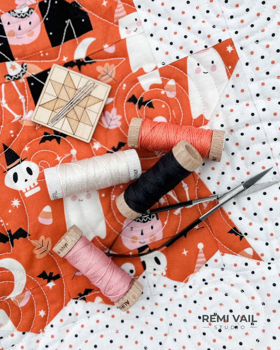 Hand embroidered quilt label that says Boo Quilt Tamara Darragh April 2025 with 3 spools of Aurifil Floss. Made and photographed by Tamara Darragh for Remi Vail Studio.