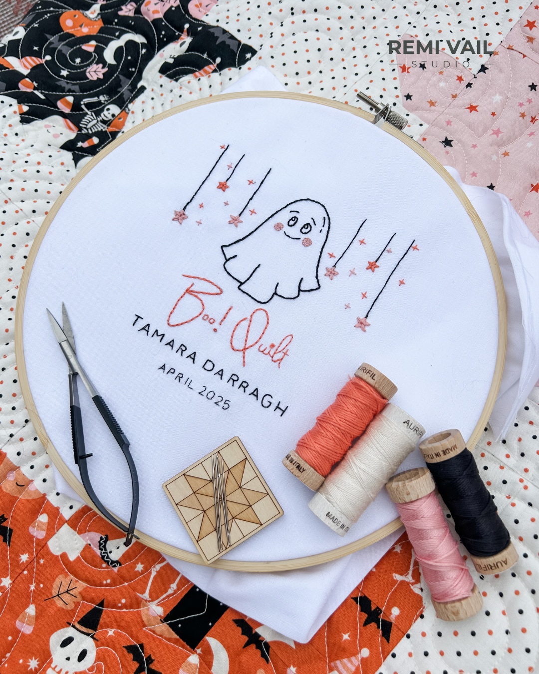 Hand embroidered quilt label that says Boo Quilt Tamara Darragh April 2025 with 3 spools of Aurifil Floss. Made and photographed by Tamara Darragh for Remi Vail Studio.