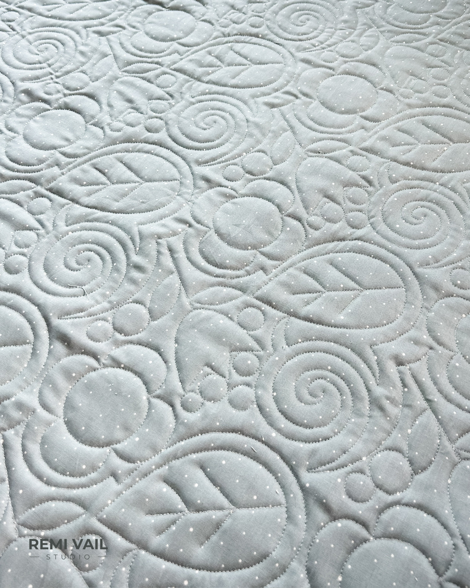 Front Porch Quilt made by Remi Vail Studio using the Cozy Bebe fabric collection by Riley Blake Designs. Quilting is shown up close. Quilt design is Cottage Core by Sew Shabby Quilting.