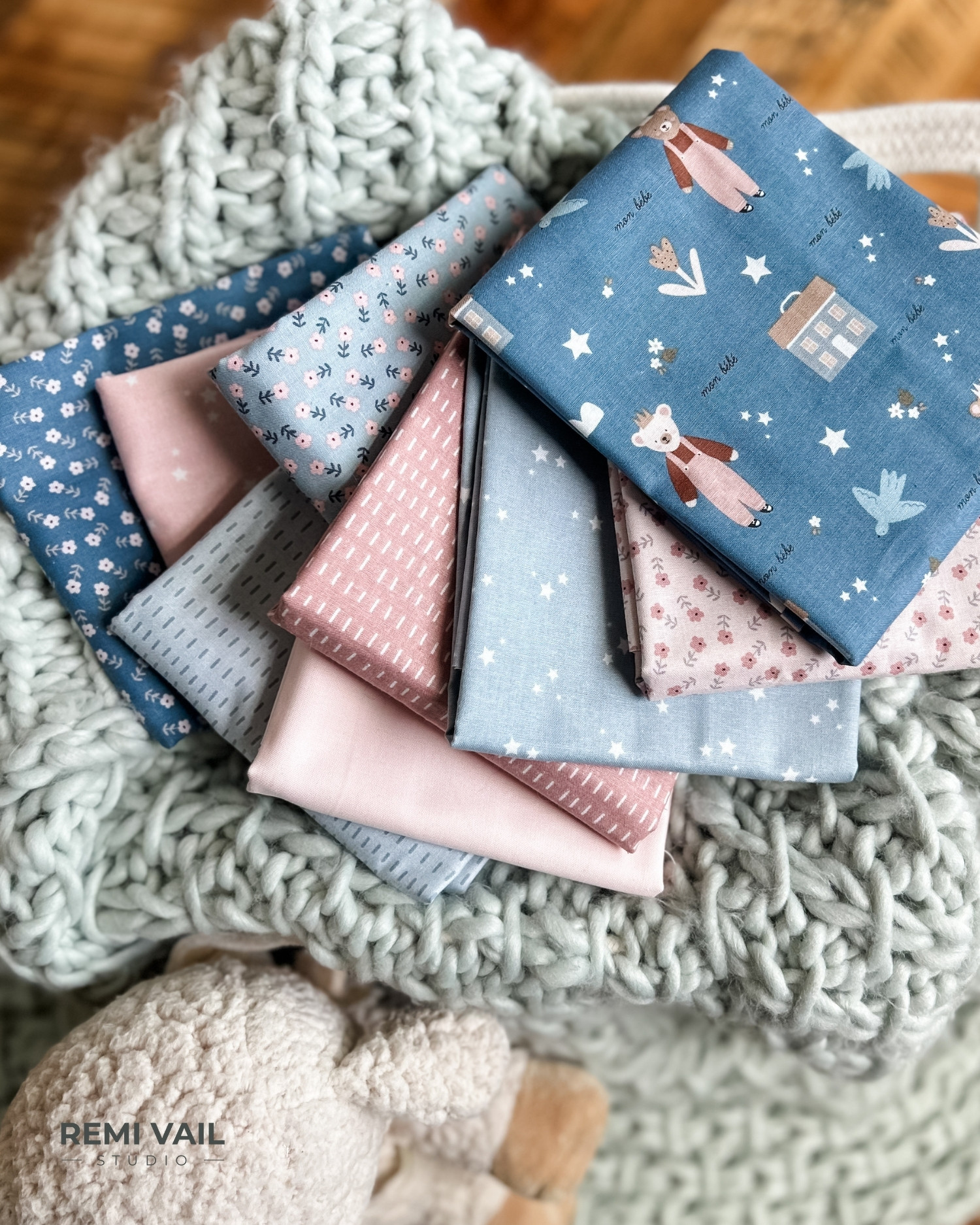 Cozy Bebe fabric collection by Riley Blake Designs. Fabric is on top of chunky knit blanket, photographed by Tamara Darragh for Remi Vail Studio.