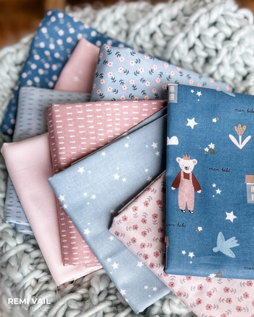 Cozy Bebe fabric collection by Riley Blake Designs. Fabric is on top of chunky knit blanket, photographed by Tamara Darragh for Remi Vail Studio.