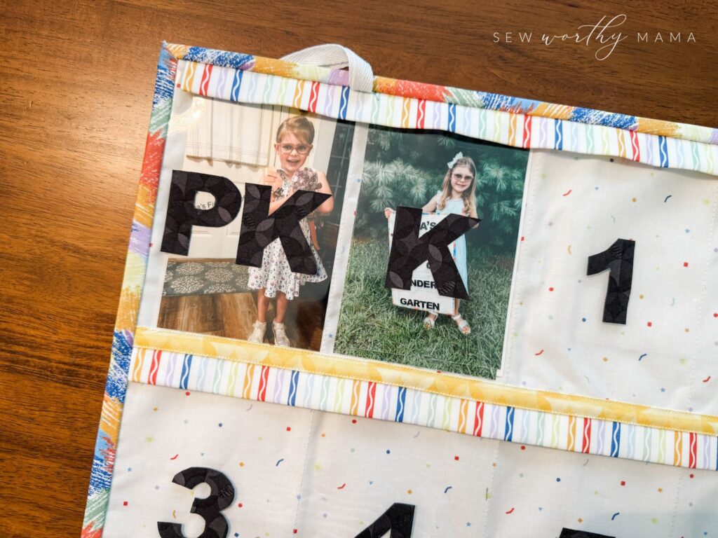 The back of a Pockets Full of Dreams project showing the clear pockets with grade level labels. The PreK and Kindergartedn pockets have photos of a girl on her first day of each grade inside them.