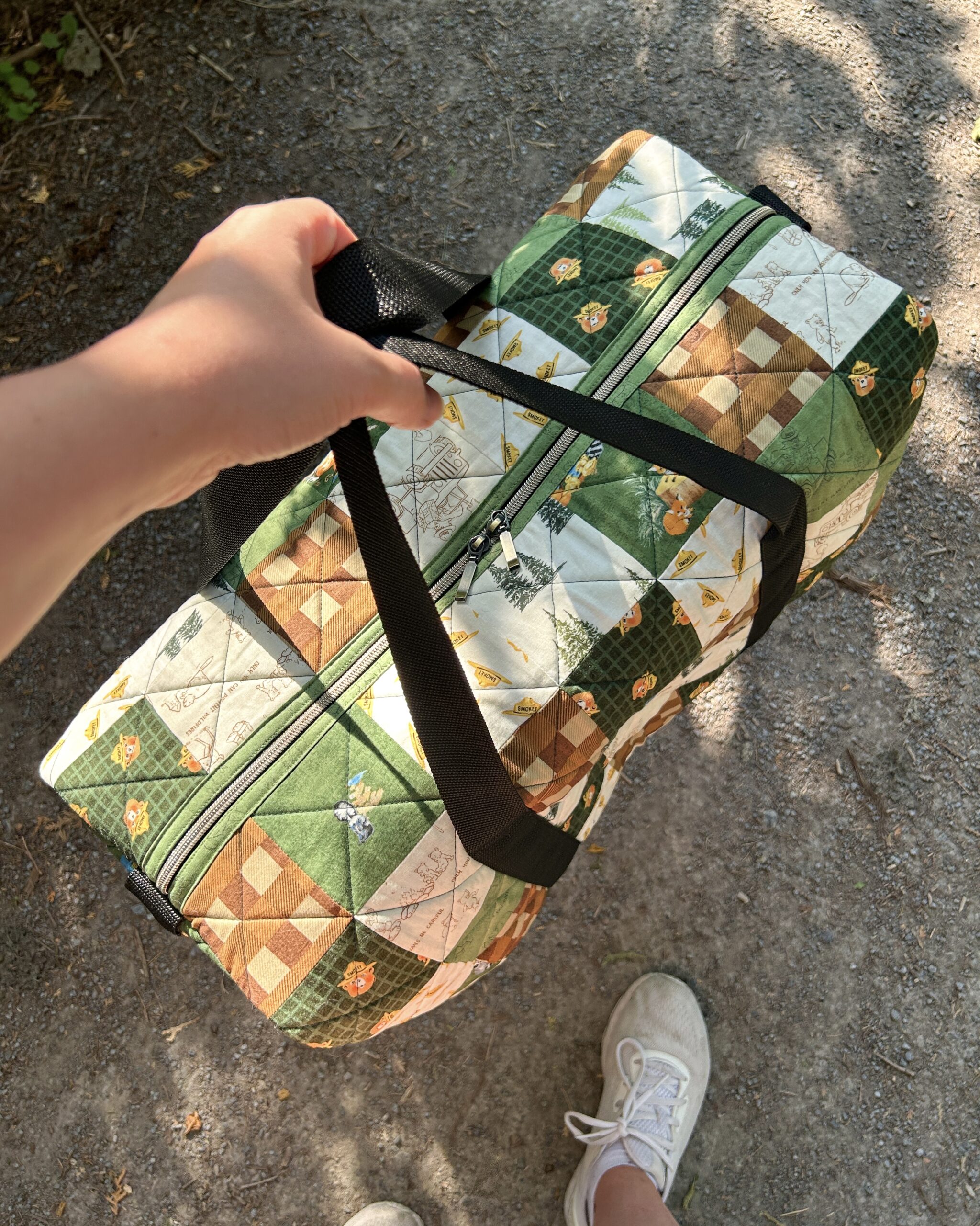 Overhead view of the patchwork duffle bag being held.