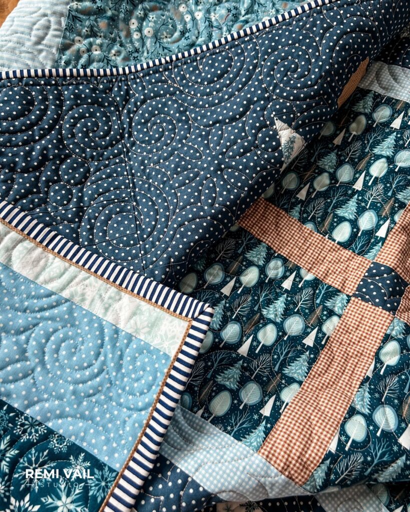 Navy striped flange binding. Lumi Quilt by Remi Vail Studio made by Tamara Darragh using the Winter Magic Fabric Collection designed by Dani Mogstad for Riley Blake Designs.  