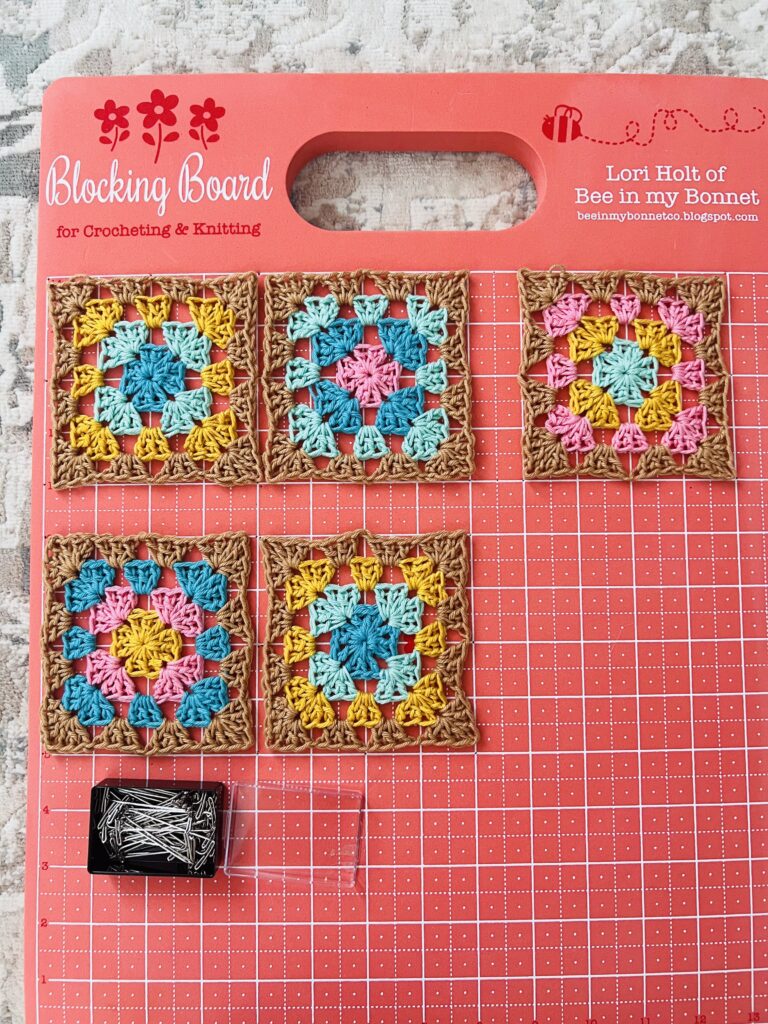 blocked granny squares on a blocking board by Lori Holt