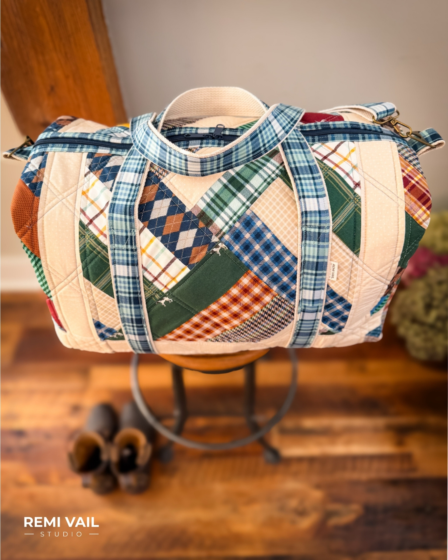 Patchwork Duffle made from Plaid Venture Club Fabric Collection. Made by Tamara Darragh of Remi Vail Studio. Duffle sitting on stool.