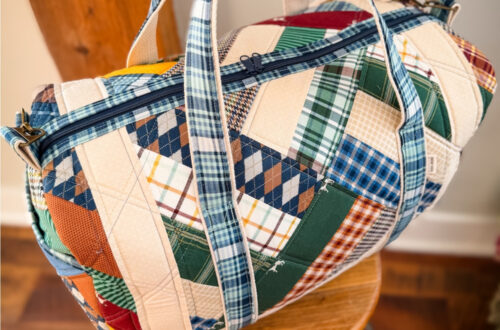 Patchwork Duffle made from Plaid Venture Club Fabric Collection. Made by Tamara Darragh of Remi Vail Studio. Duffle sitting on stool.