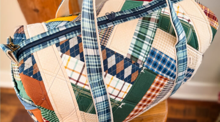 Patchwork Duffle made from Plaid Venture Club Fabric Collection. Made by Tamara Darragh of Remi Vail Studio. Duffle sitting on stool.