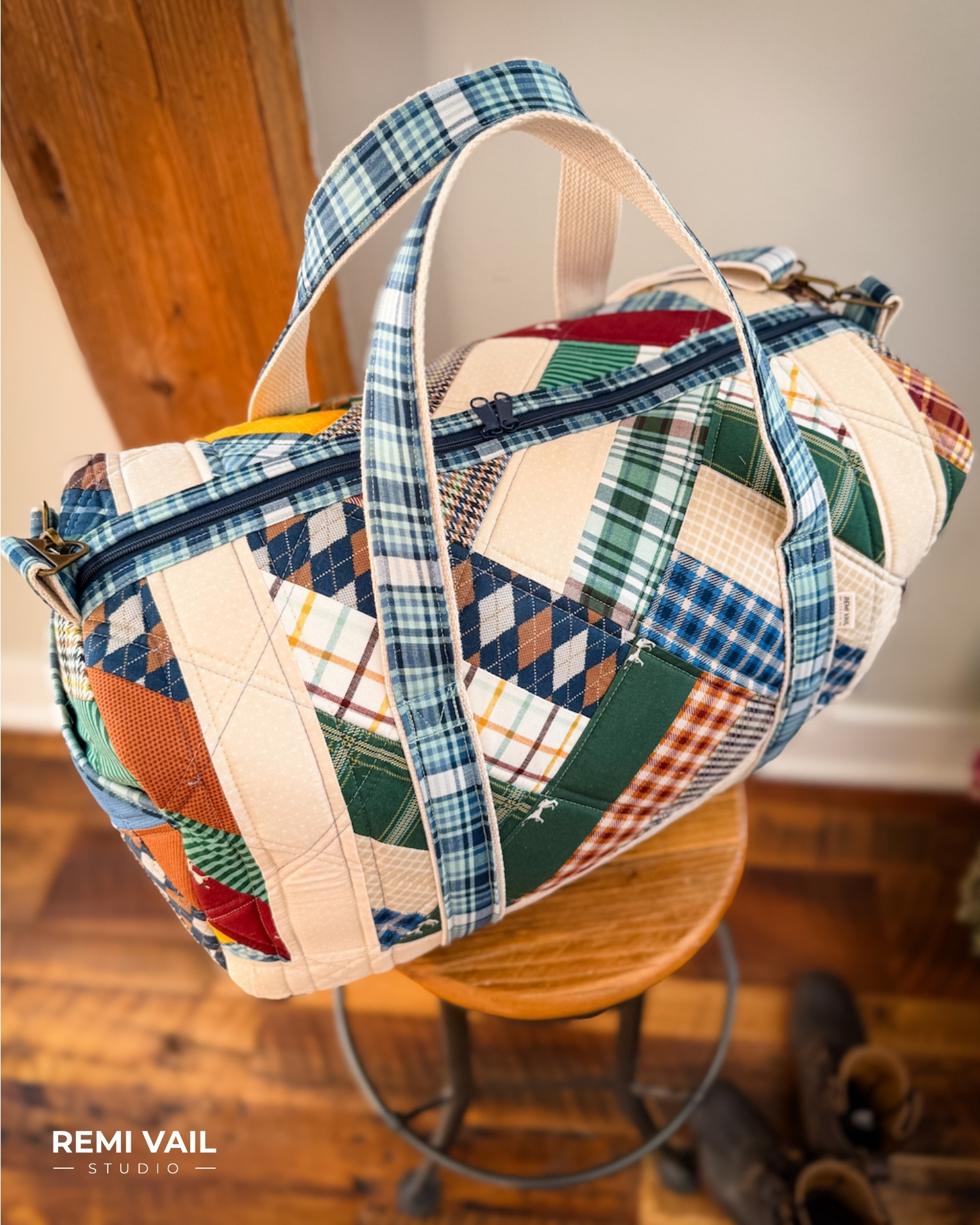 Patchwork Duffle made from Plaid Venture Club Fabric Collection. Made by Tamara Darragh of Remi Vail Studio. Duffle sitting on stool.