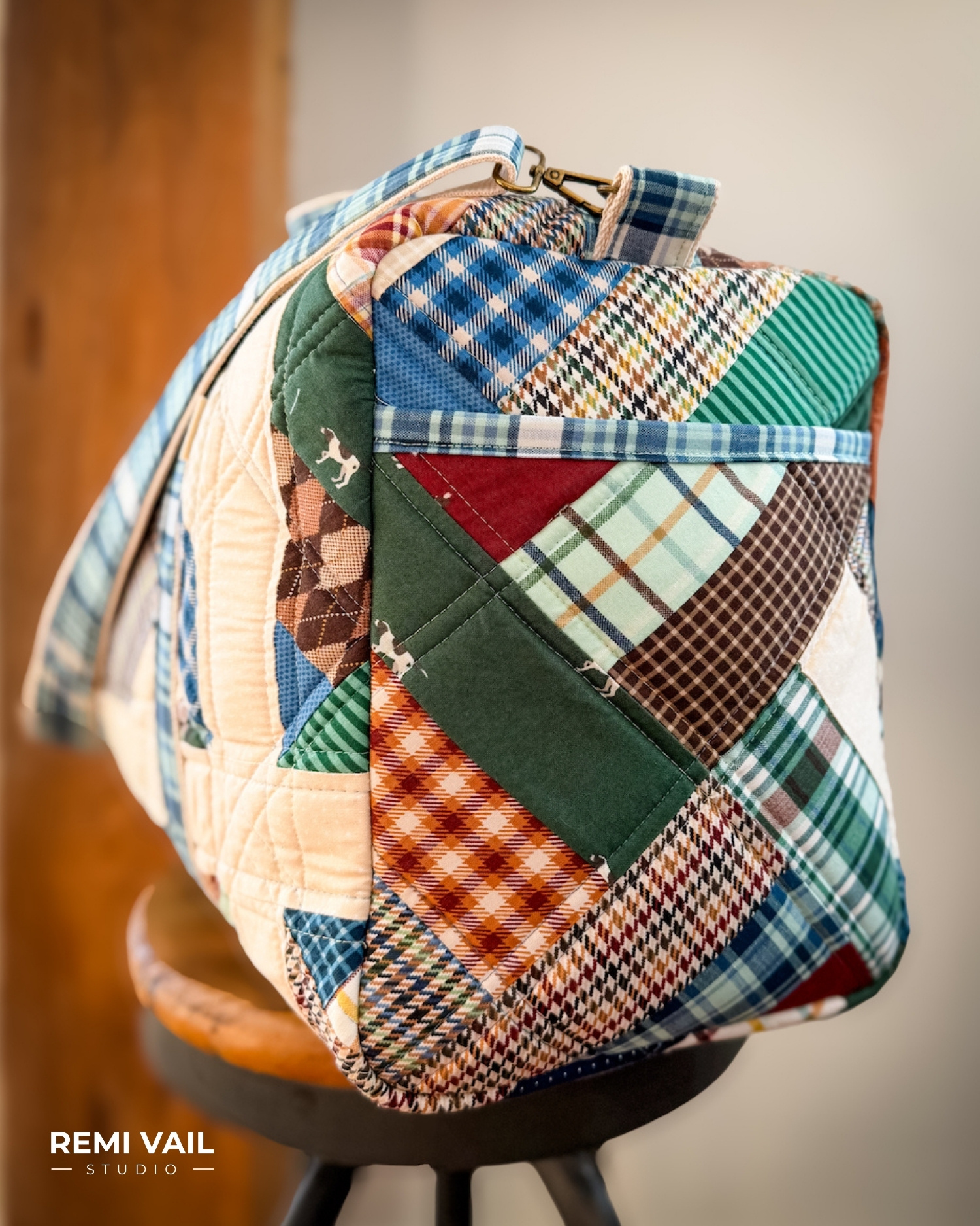 Patchwork Duffle made from Plaid Venture Club Fabric Collection. Made by Tamara Darragh of Remi Vail Studio. Duffle sitting on stool.