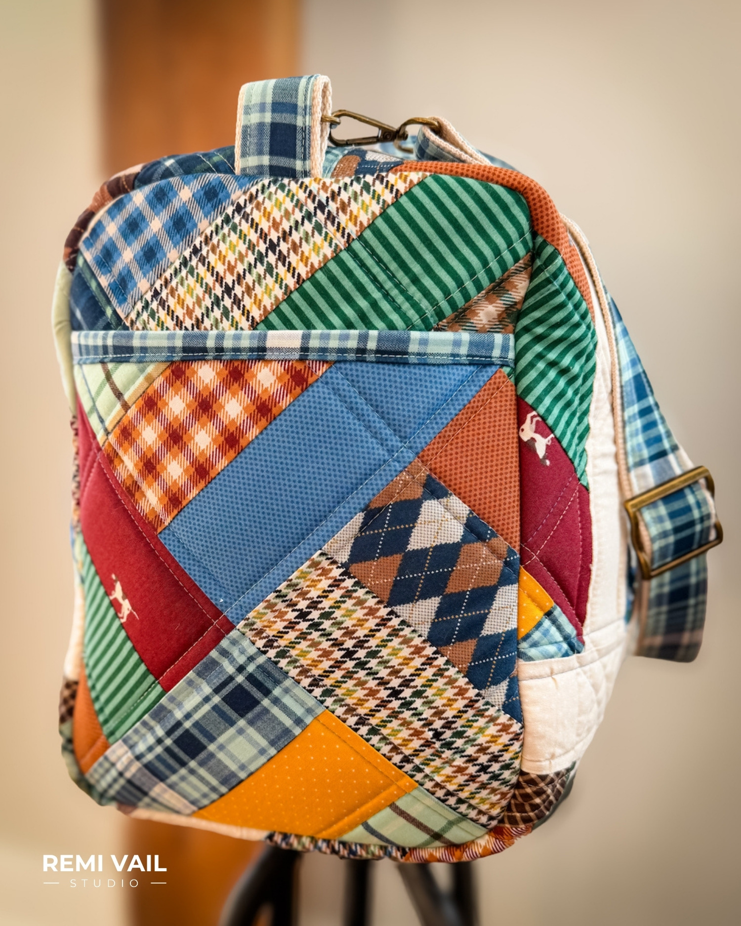 Patchwork Duffle made from Plaid Venture Club Fabric Collection. Made by Tamara Darragh of Remi Vail Studio. Duffle sitting on stool.