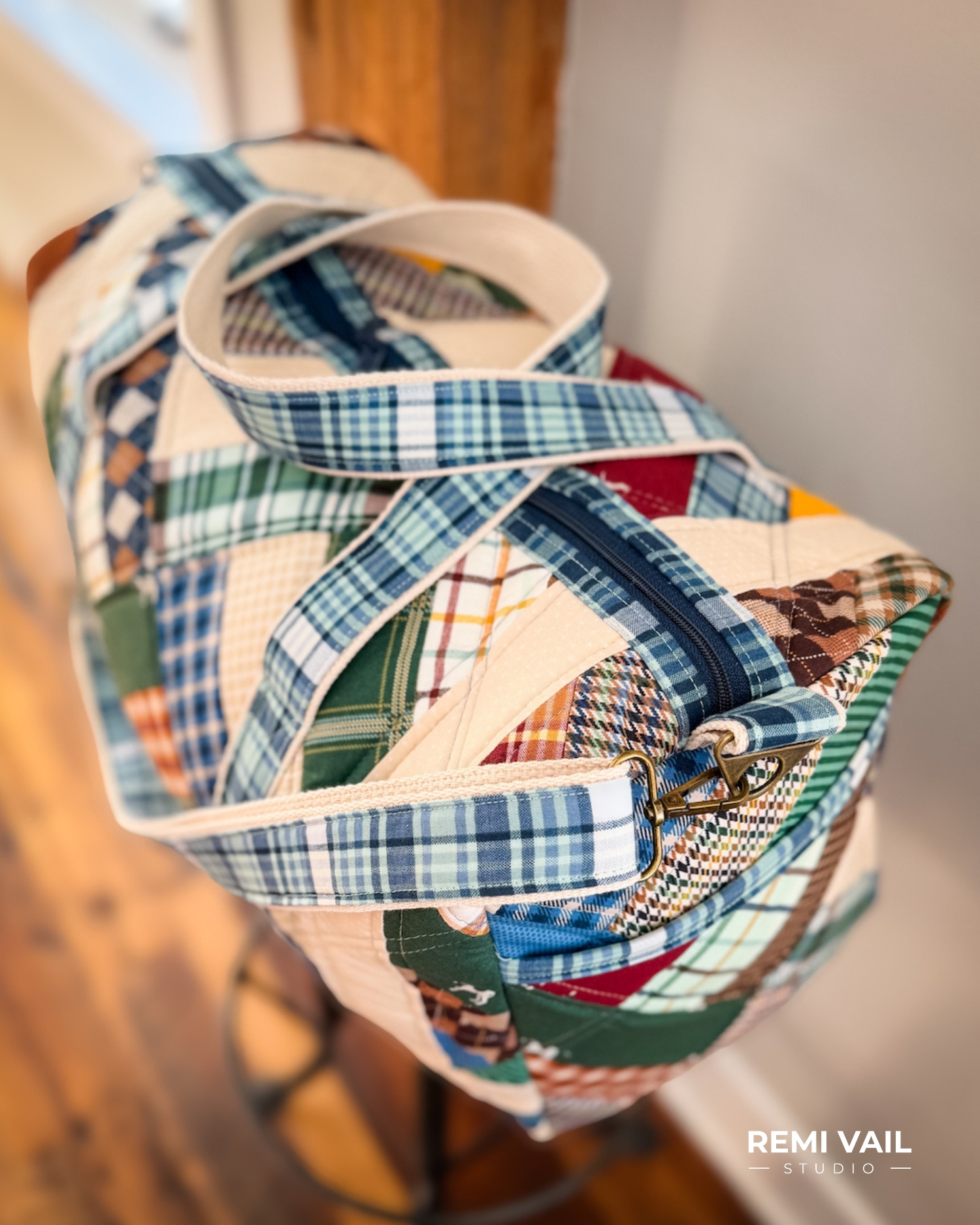 Patchwork Duffle made from Plaid Venture Club Fabric Collection. Made by Tamara Darragh of Remi Vail Studio. Duffle sitting on stool.