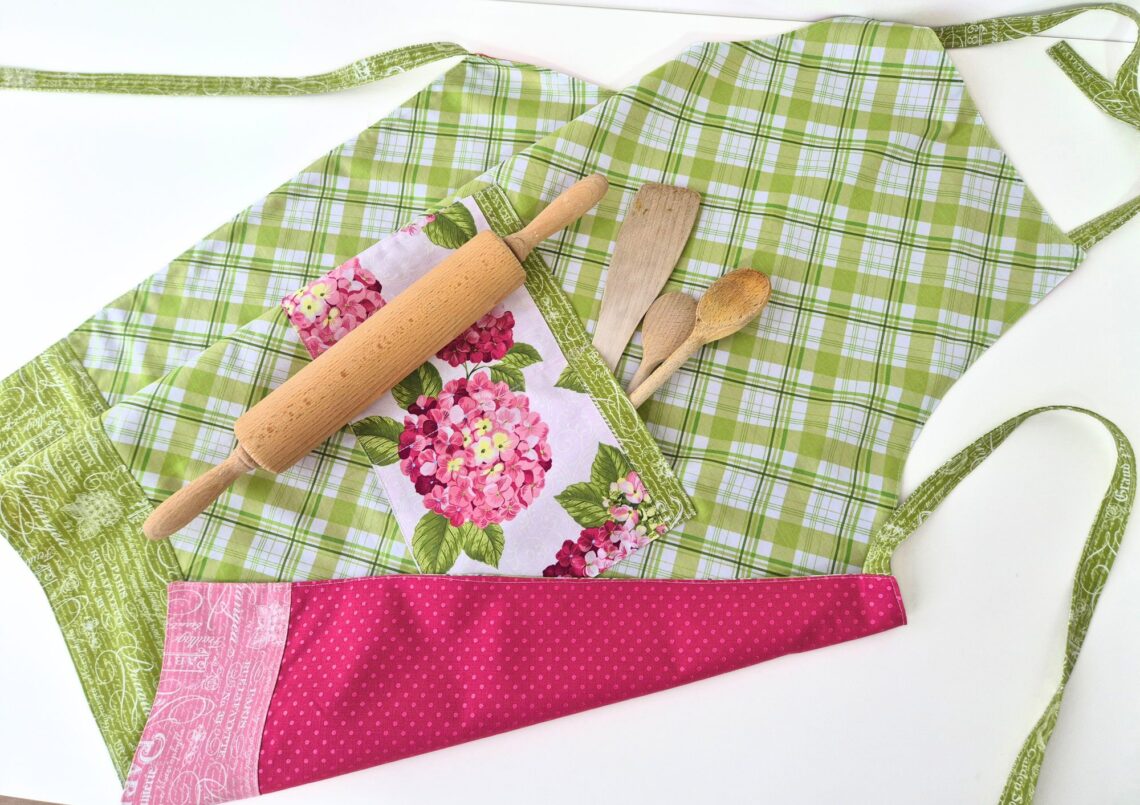 Finished reversible apron with hydrangea pocket and baking tools.