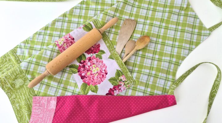 Finished reversible apron with hydrangea pocket and baking tools.
