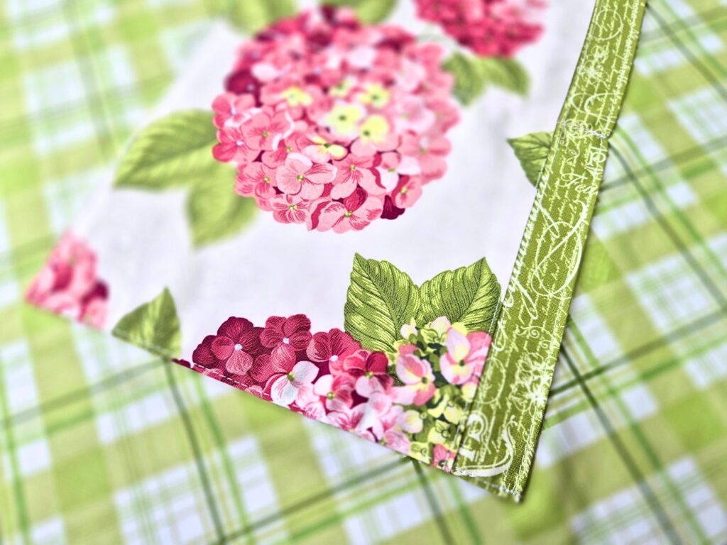 Close-up of hydrangea fabric and apron tie on the finished reversible apron.
